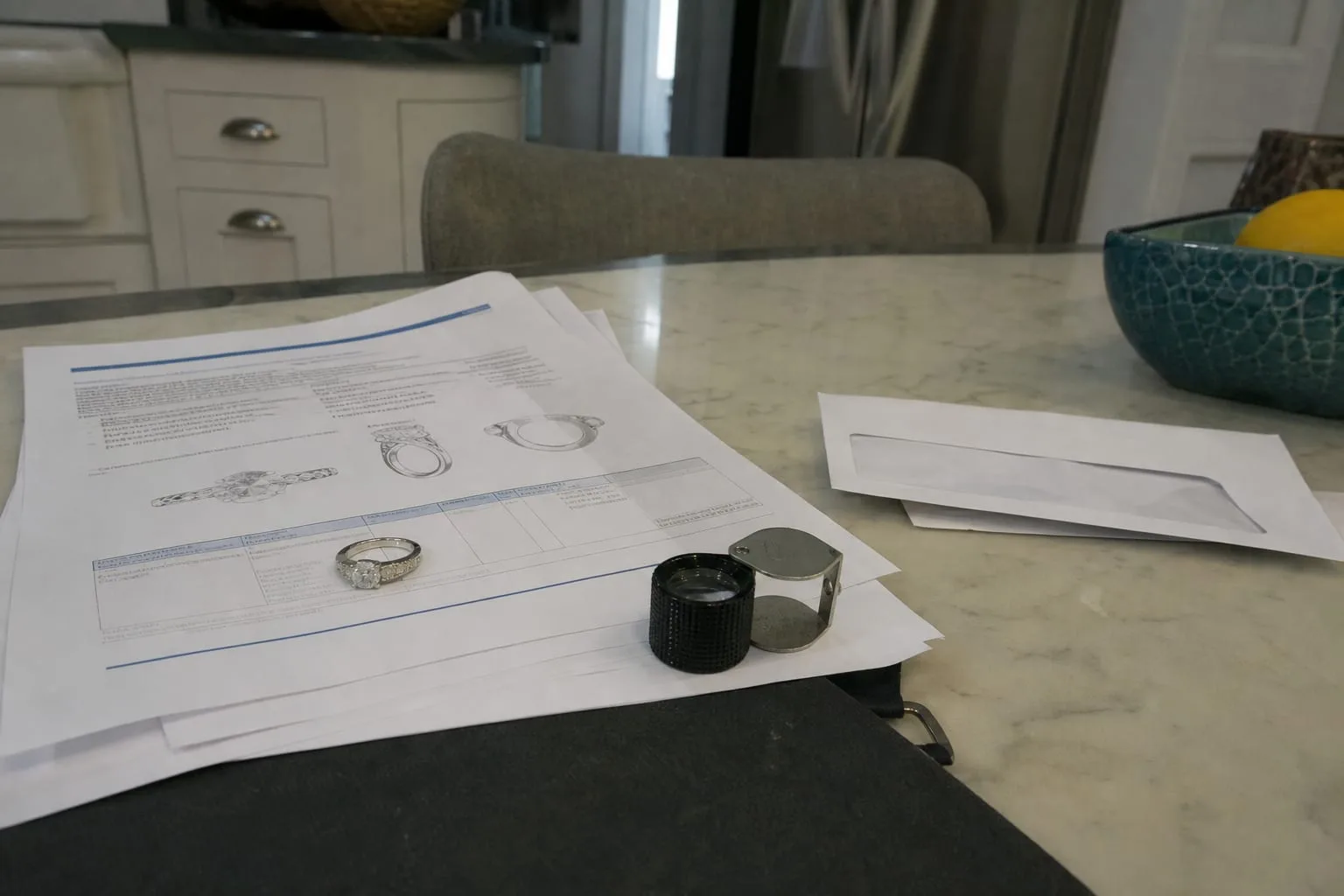 A platinum ring with a center diamond and small side stones resting on a printed multi-page insurance appraisal report beside a jeweler's loupe and a renewal...